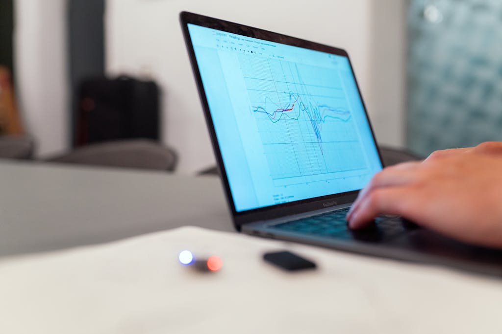 A person working on a graph analysis on a laptop for data monitoring and research.