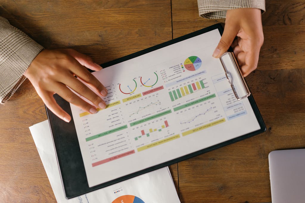 Top view of hands holding a financial report with colorful graphs and charts, ideal for business presentations.